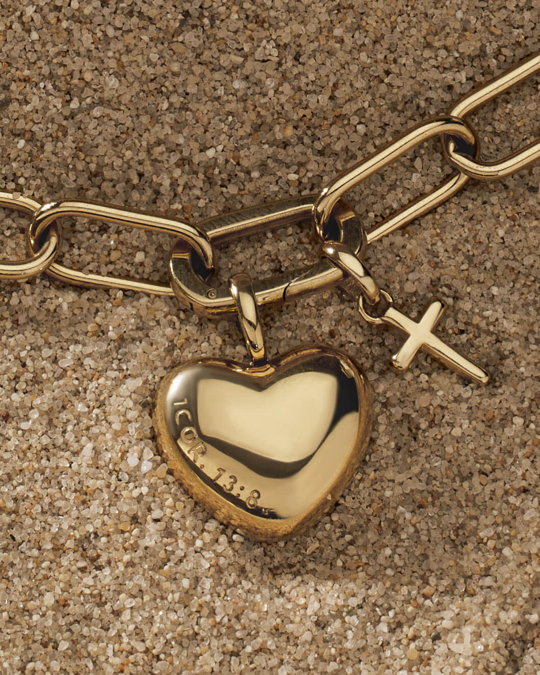 Close-up of Love Never Fails 1 Corinthians 13:8 Gold Heart Pendant