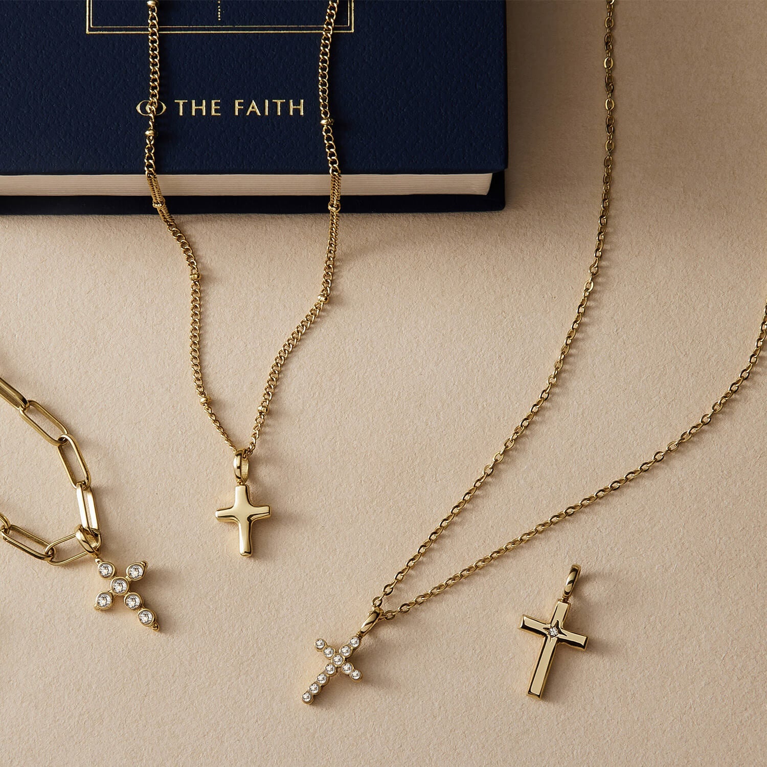 A styled flat-lay image of gold cross pendants and necklaces.