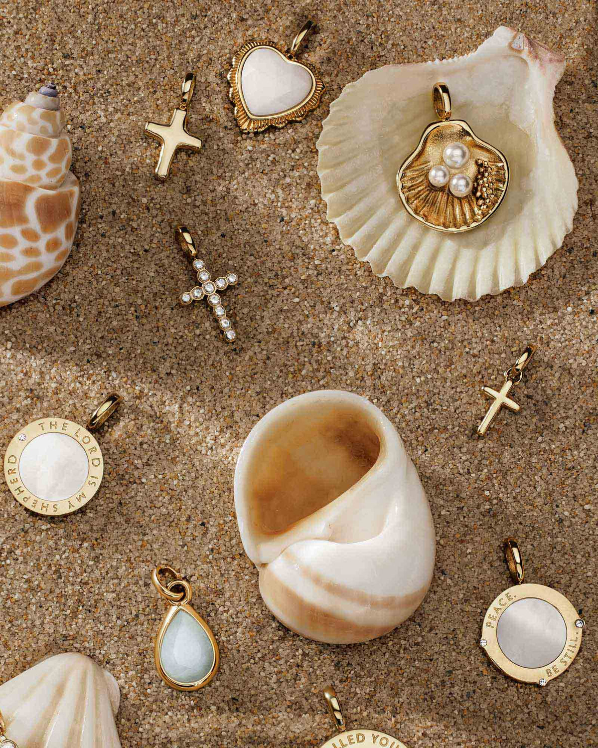 Various Gold Pendants amongst shells and sand