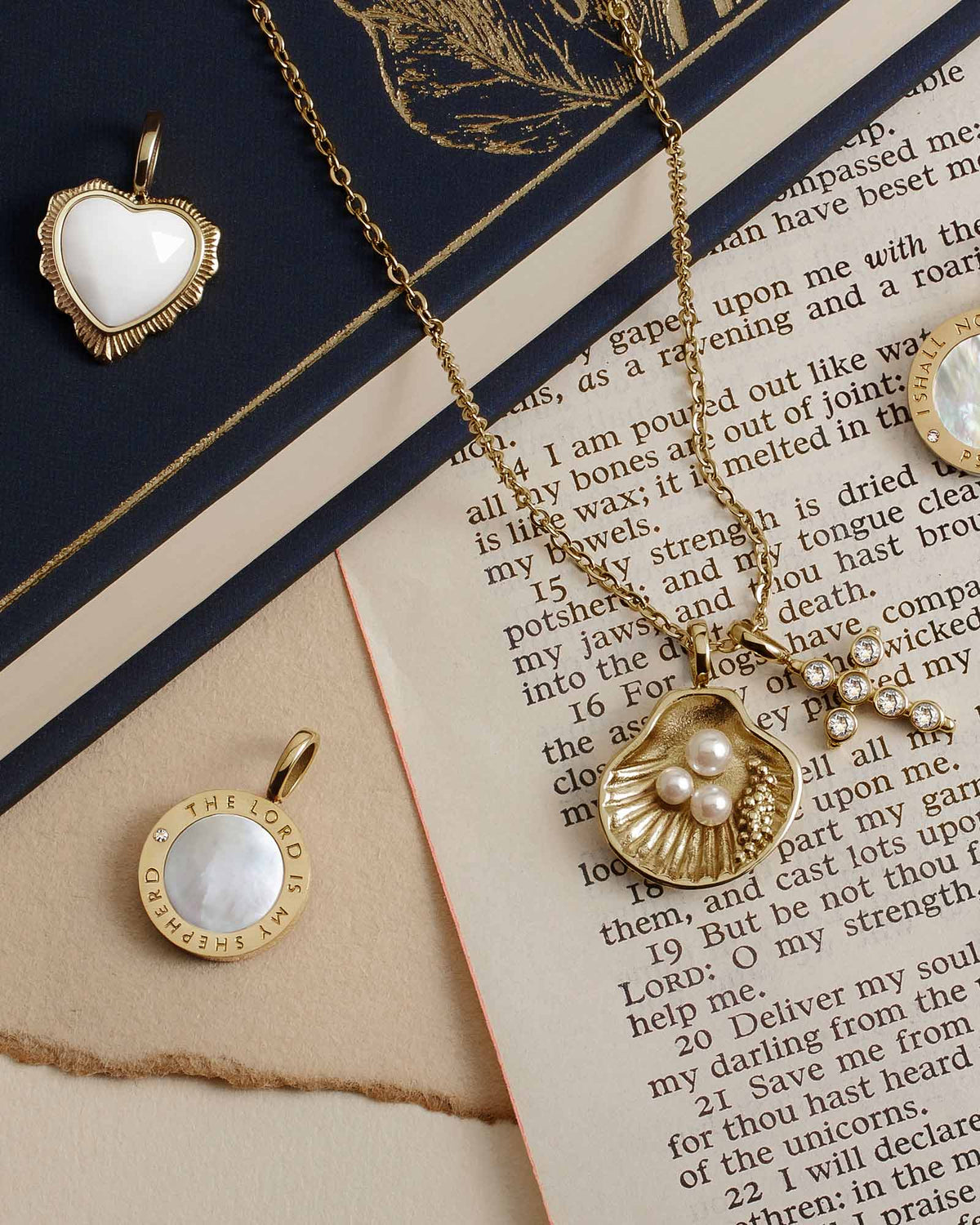 Psalm 23 Gold Pendant with various other pendants against Bible excerpt
